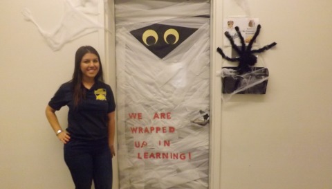 Ms.Tomasyan, math teacher at Animo Jefferson Charter Middle School stands beside her decorated classroom door. She enjoyed the taste of victory on winning the door decorating contest on November 1st.