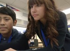 8th-grader Daria Ayala helps her fellow student peer (Alejandro Salas, 8th-grader) upload photos. After a few moments, he understood what to do, and so Daria continued with her own work.
