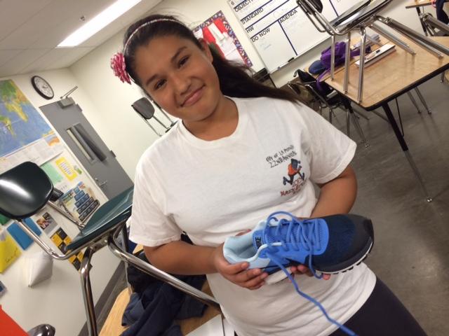 Eighth grade Srla runner, Alma Gonzalez is holding her new shoes she recieved. She is planning to use these shoes for the LA Marathon.