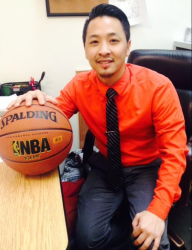 Basketball coach, Thomas Lo, showing his basketball. 
