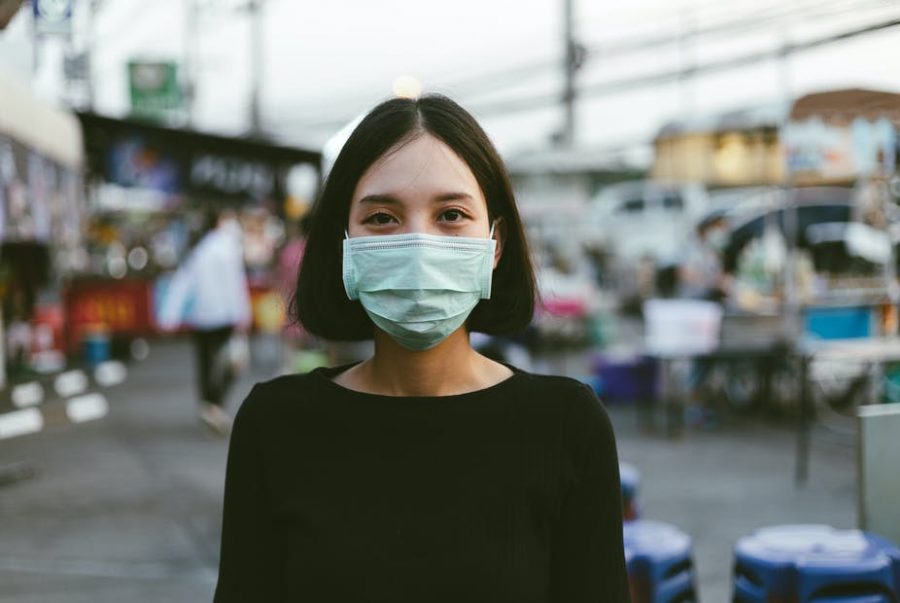 This photo shows a woman wearing a face mask properly outside.