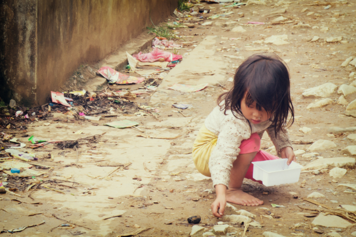 Young girl out of school looking for money or food.