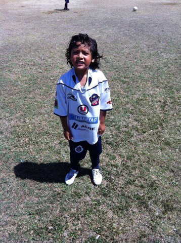 Cristian Larios standing in his uniform from his old soccer club.