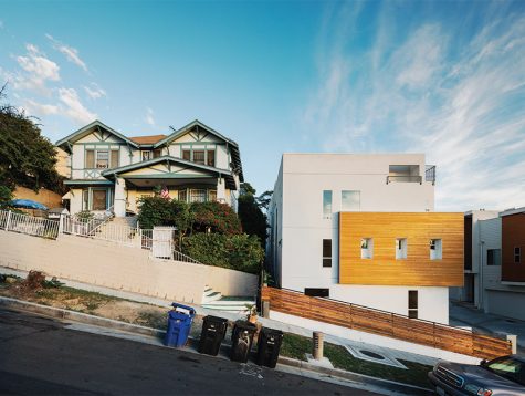 Two houses beside each other. One is a modern-looking house while the other is a very old, run down house.