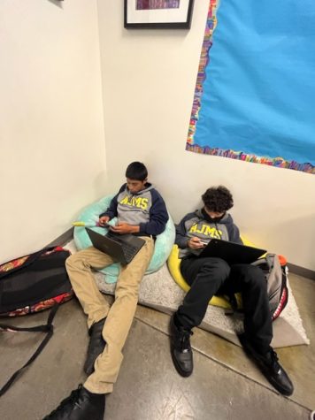 Mikey Morales and Jorge Rios relaxing while they work in investigations class.