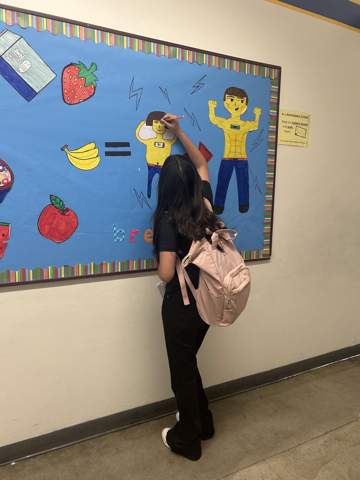 Geraldine is drawing on the bulletin board for student council.