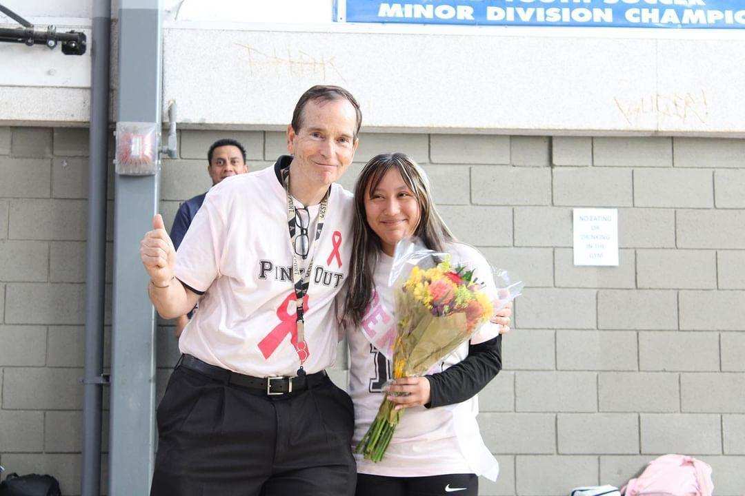 After the game on Senior Night Brisa took a picture with Coach Wright after he gave her flowers.