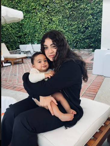 Esther babysitting a baby that wasn't feeling good with her mom at the baby's parents' house. 