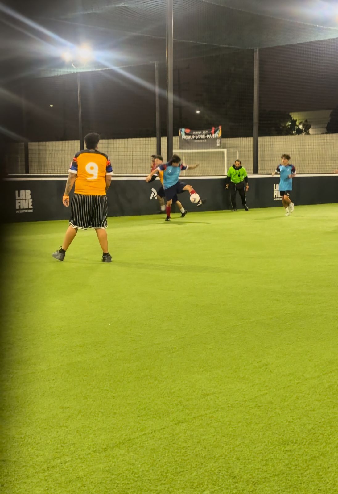 My brother in blue, kicking the ball, playing soccer.