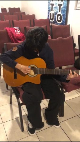 Cesia at church learning how to play the guitar.