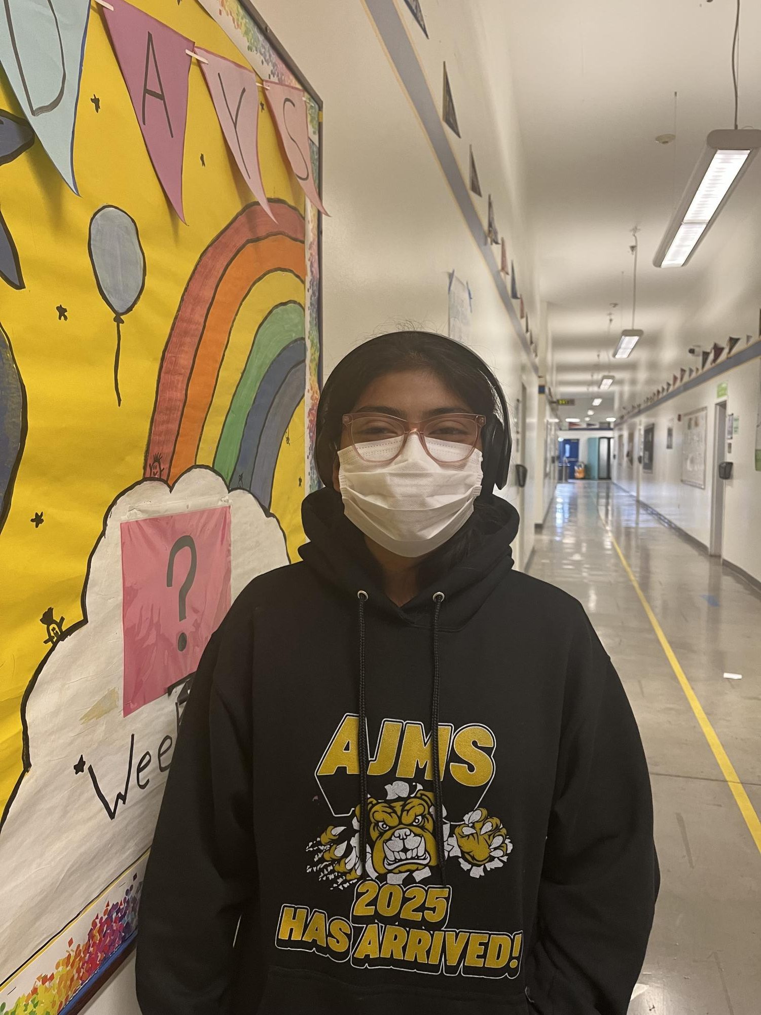 Jayleen standing next to a bulletin board made by Student Council members.