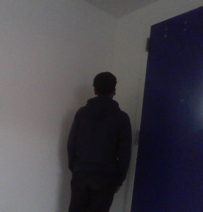 Mathew standing in a corner because he takes pictures like this with his friends.