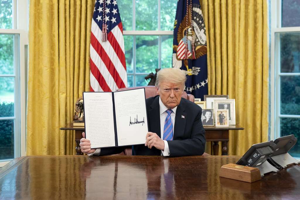 President Trump showing his signature after signing an executive order.