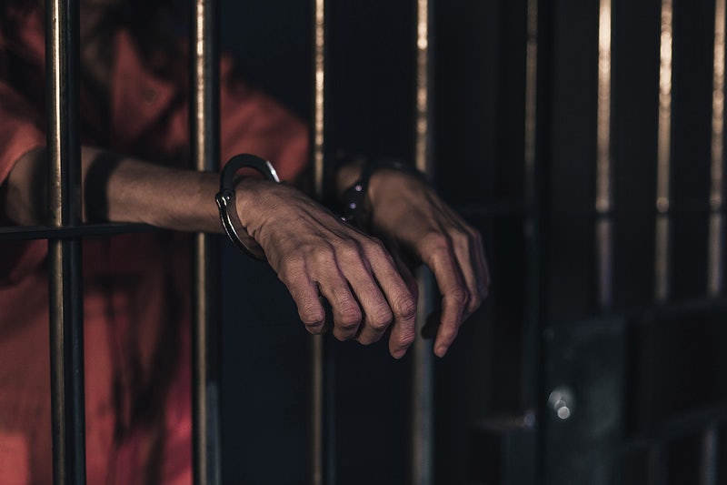 A person handcuffed in prison.