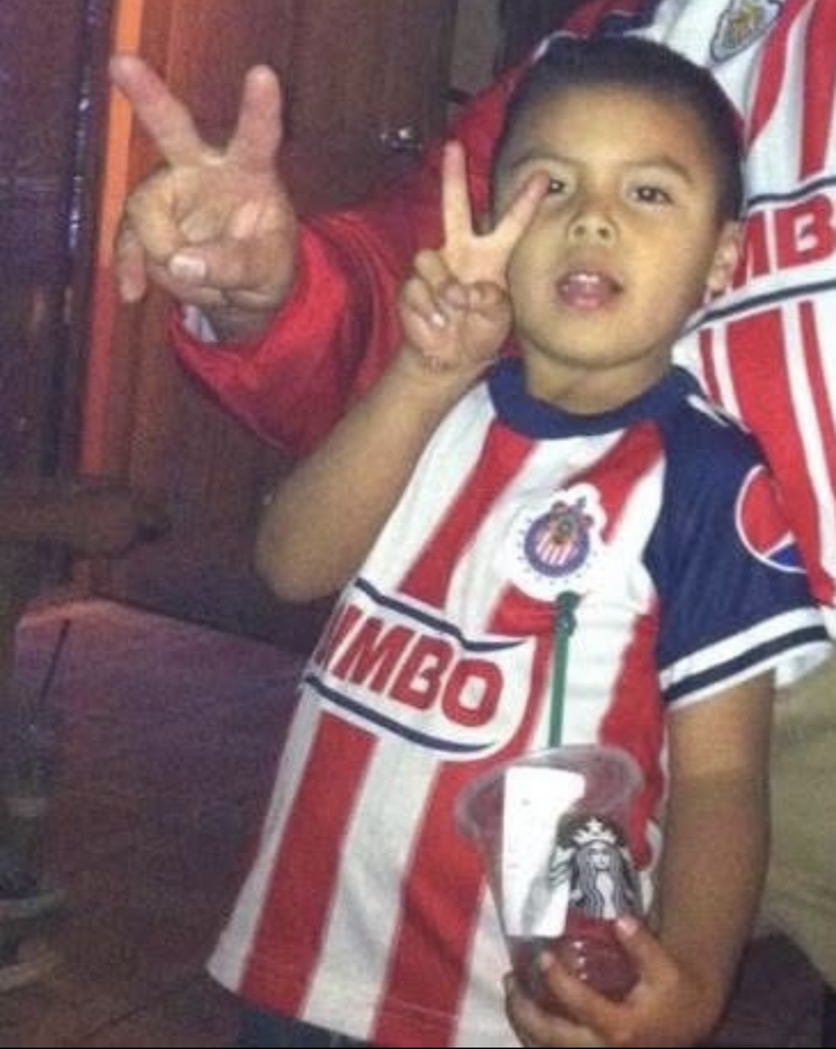 Emiliano watches a Chivas game with his family.