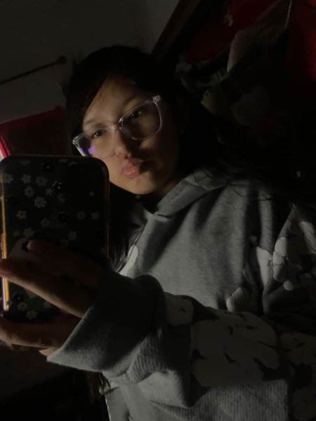 Daniela takes a photo of herself in front of her mirror.