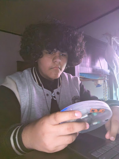 Erik holds a CD player in his hand. He was going to insert his burned CD of "The Wall" album before starting his homework.