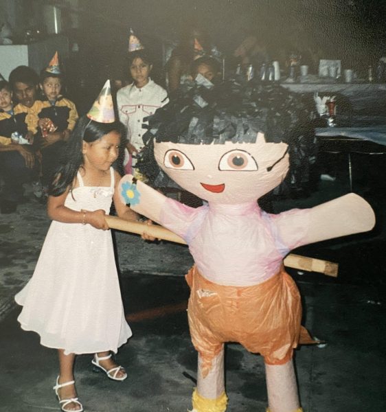 Yesenia Fuentes hits the Dora pinata.  This was picture was taken at her Dora-themed birthday birthday.   

