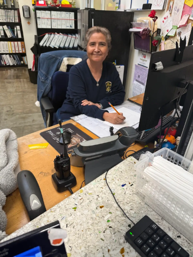 Ms. Elvia workis at her desk in the front office.