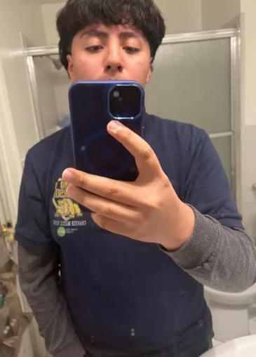 Josue takes a picture in the bathroom.