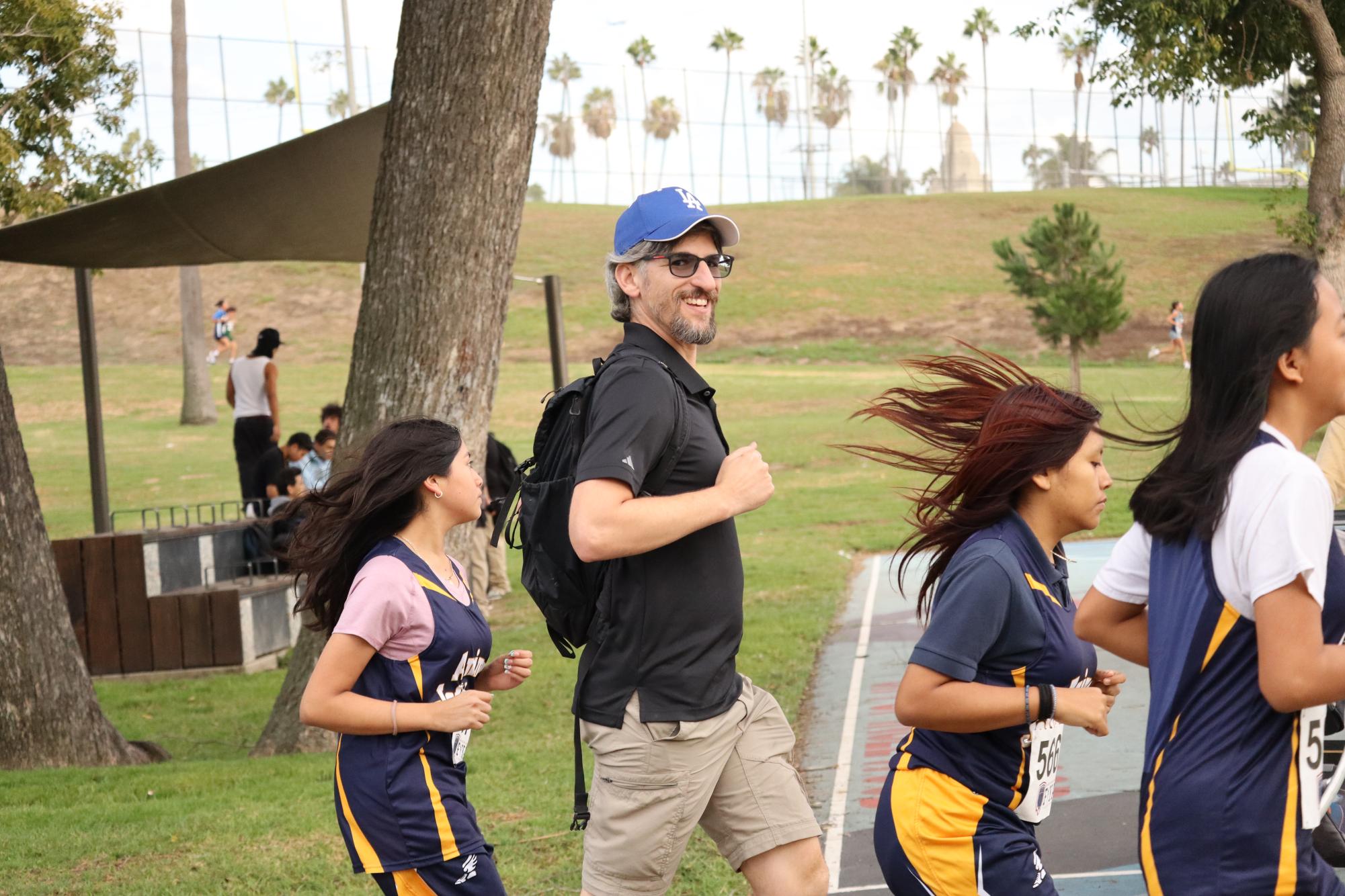 Coach Carl Finer, Sarai Ronquillo, Janett Garcia, and Litzy Sales warming up for the one mile girls race. (All eighth graders except for Finer)