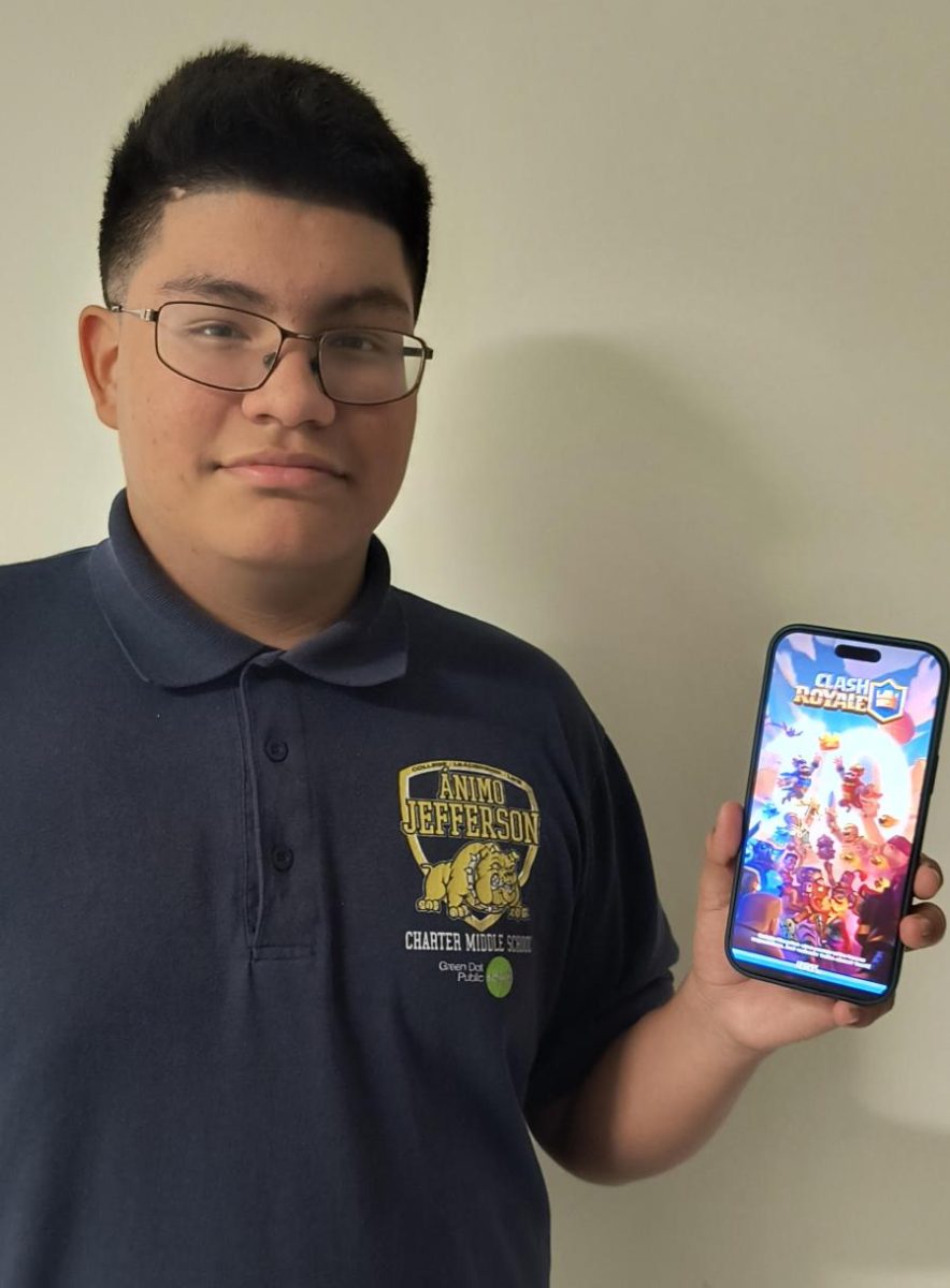 Fernando holding up his phone with Clash Royale on it.