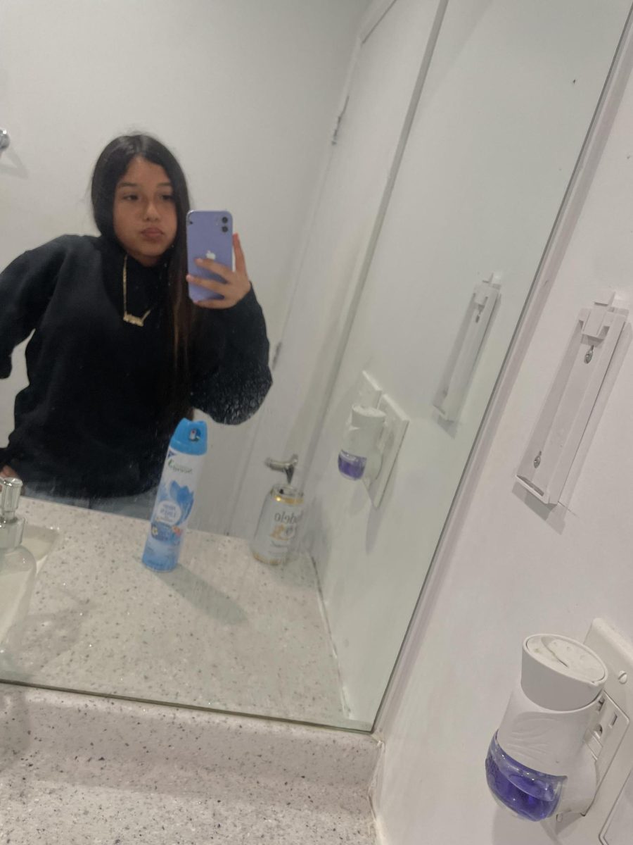 Jasmine taking a selfie in the restroom mirror.