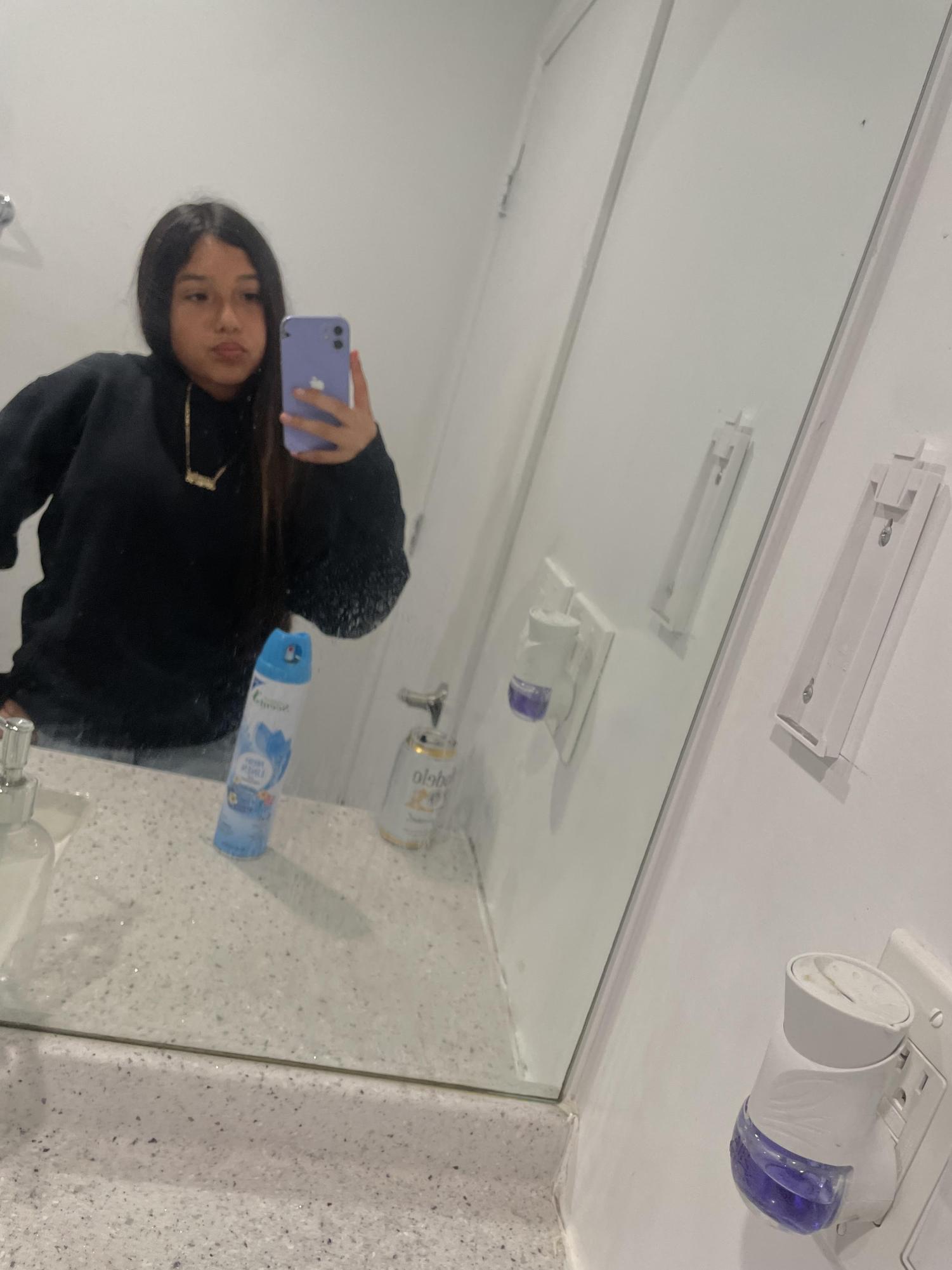 Jasmine taking a selfie in the restroom mirror.