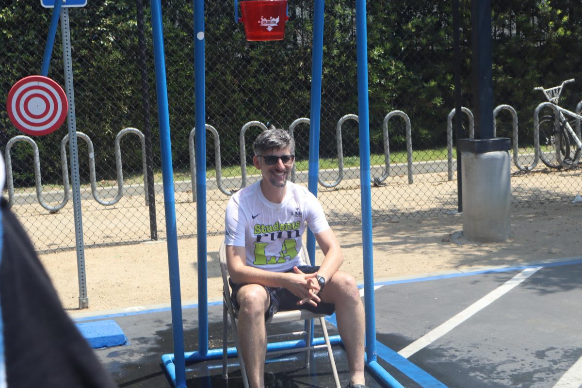 Teacher Carl Finer sitting on a chair waiting for the water to fall on his head.