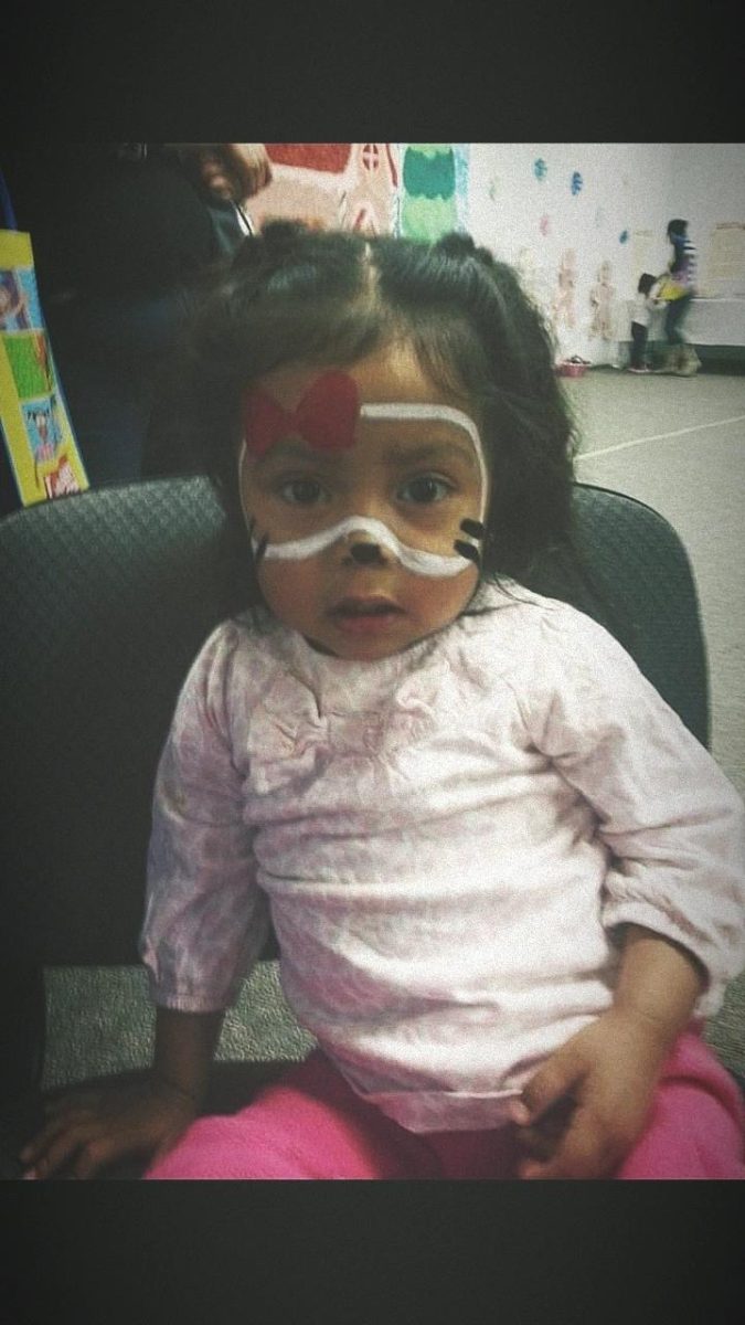 Amy sitting down for a picture after getting her face painted.